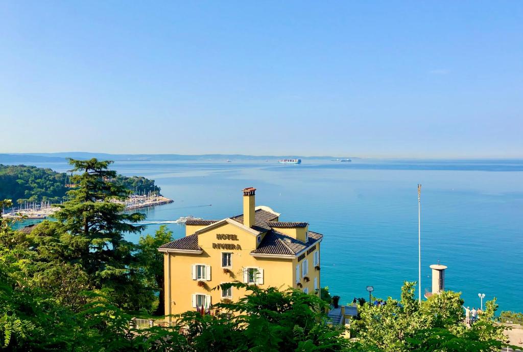 a house on a hill overlooking the water at Hotel Riviera & Maximilian's in Trieste