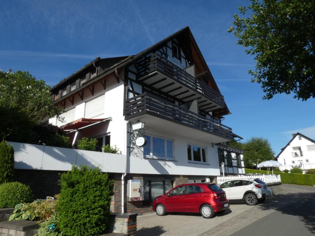 un coche rojo estacionado frente a un edificio en Gasthof Westfeld en Schmallenberg