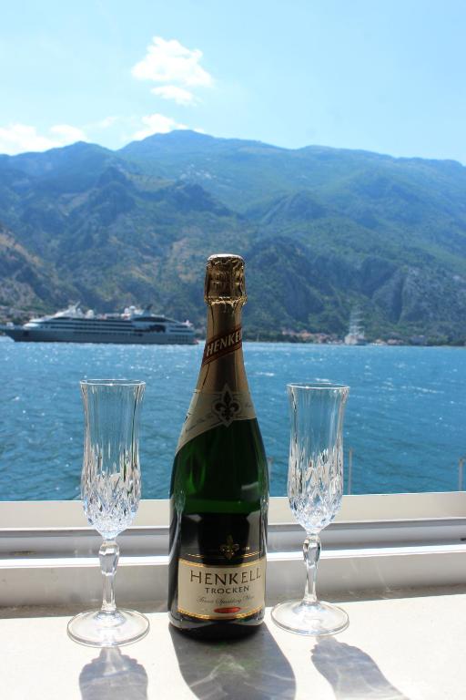 a bottle of champagne and two glasses on a table at Piano apartments in Kotor