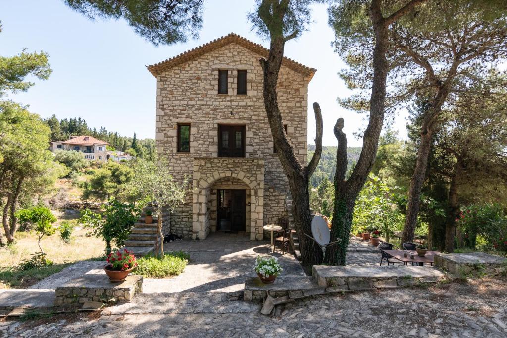 una casa in pietra con un albero di fronte di Villa Castello a Ágios Nikólaos