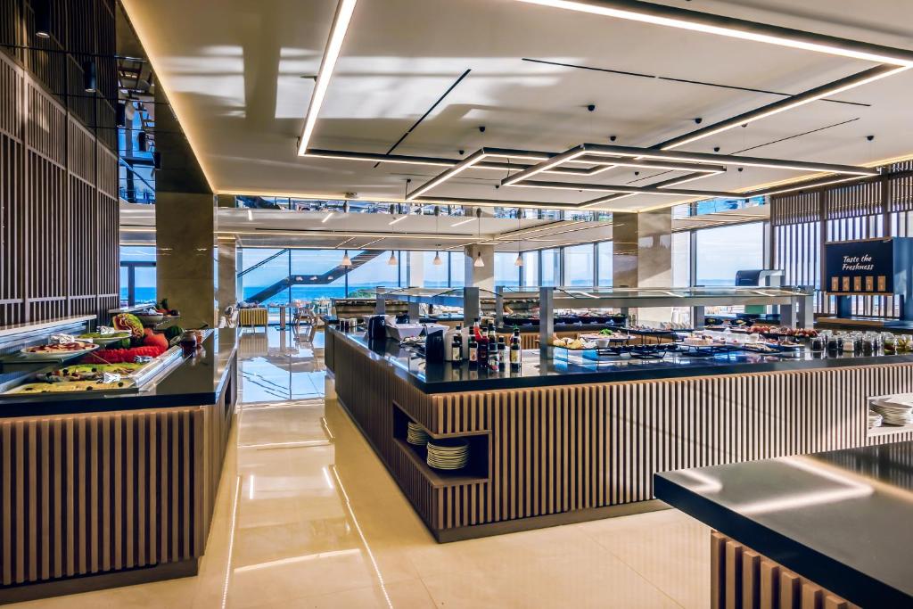 a restaurant with a buffet line in a building at Ammoa Luxury Hotel & Spa Resort in Nikiti