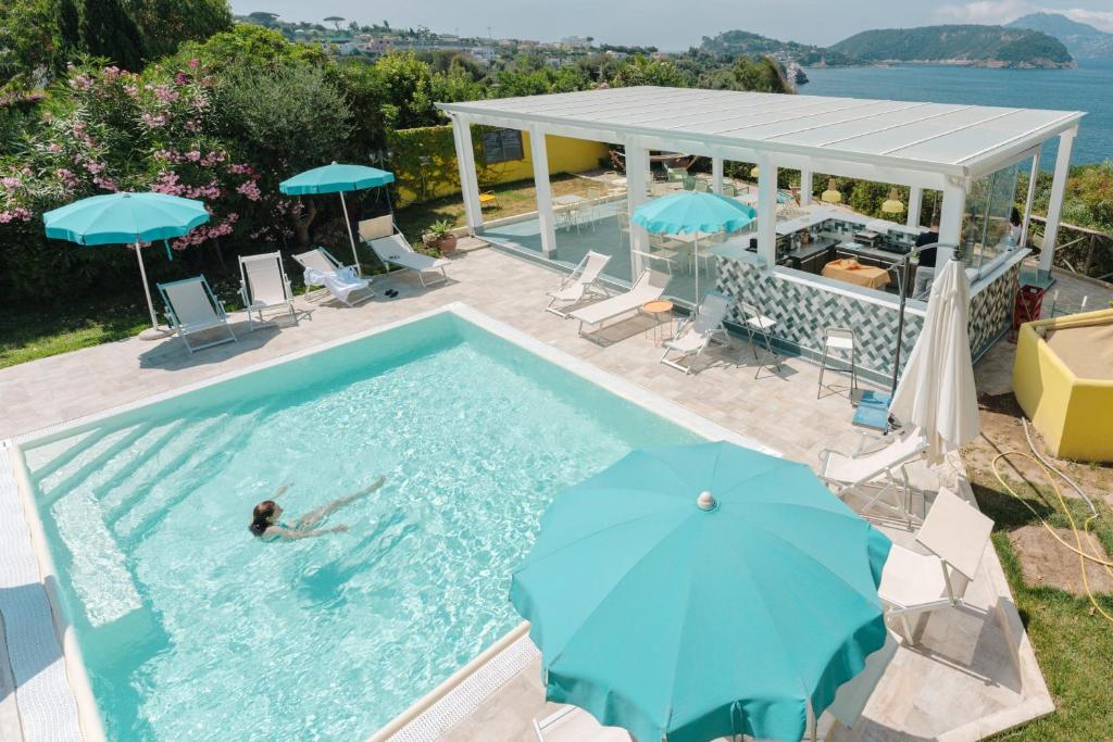 a person swimming in a swimming pool with an umbrella at Solcalante in Procida