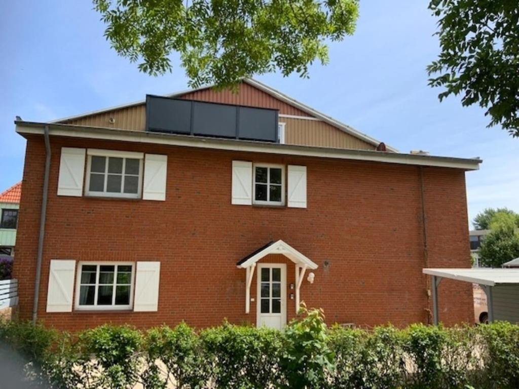 a red brick house with a solarium on the roof at Stadtquartier 1 EG in Bredstedt