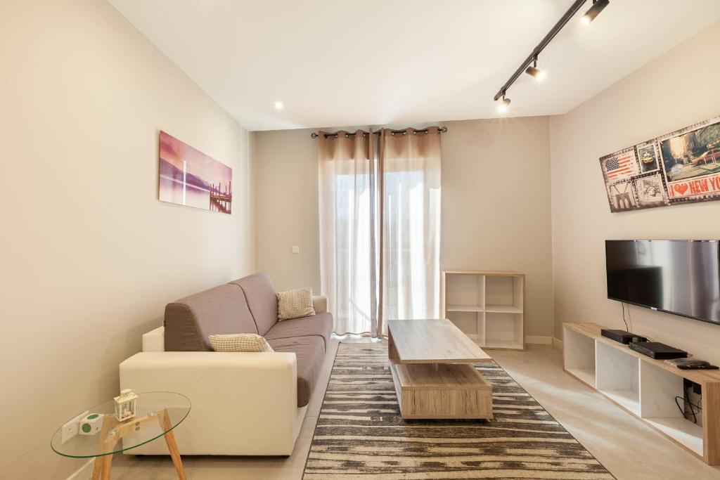 a living room with a couch and a tv at Brand new 1BR in central MALTA-Hosted by Sweetstay in Tal-Pietà