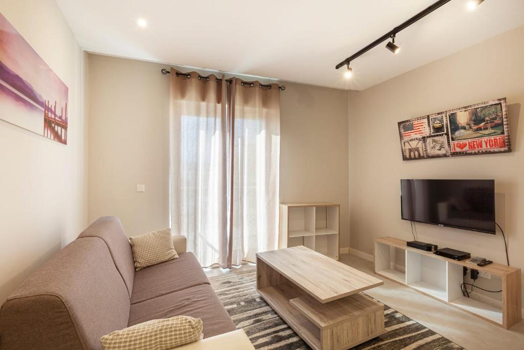 a living room with a couch and a tv at Brand new 1BR in central MALTA-Hosted by Sweetstay in Tal-Pietà
