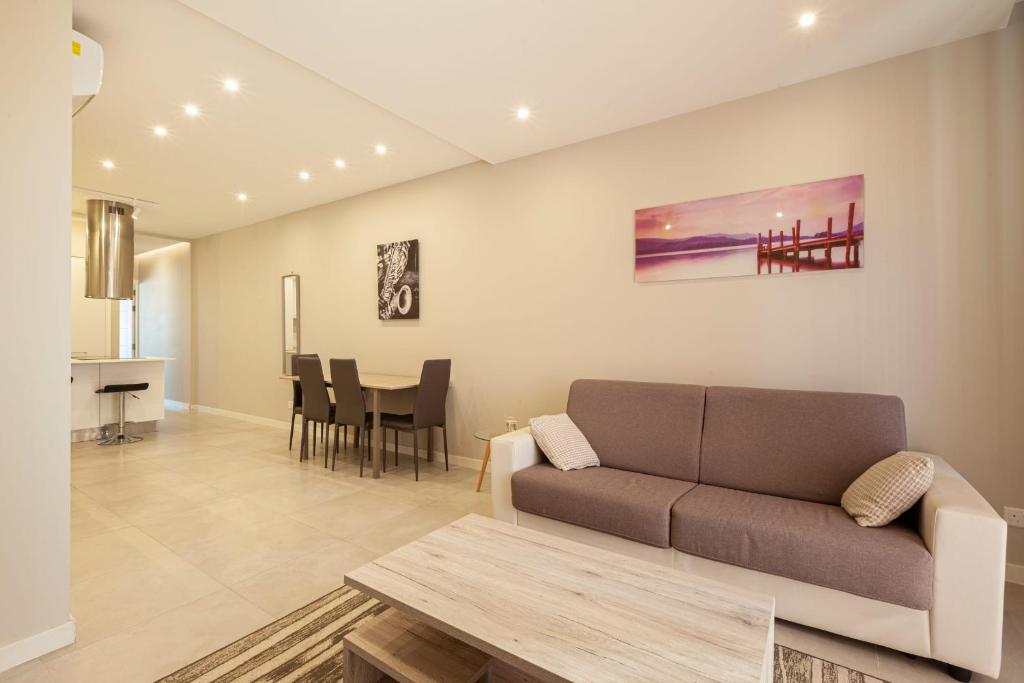 a living room with a couch and a table at Brand new 1BR in central MALTA-Hosted by Sweetstay in Tal-Pietà