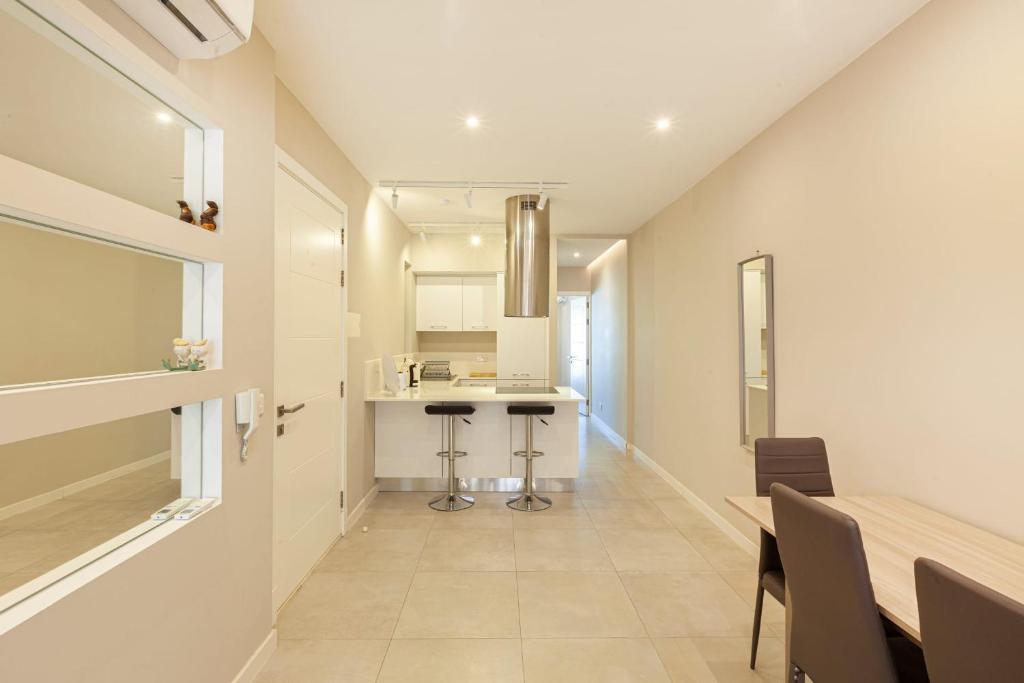 a kitchen and dining room with a table and chairs at Brand new 1BR in central MALTA-Hosted by Sweetstay in Tal-Pietà