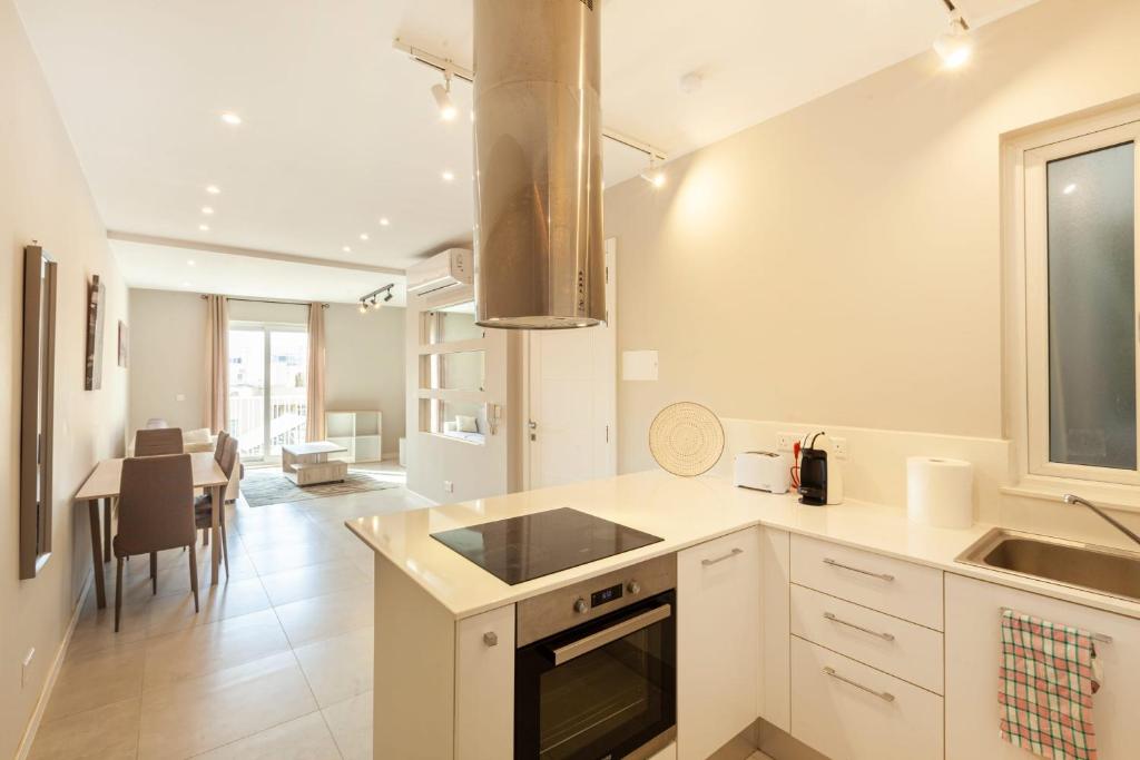 a kitchen with a sink and a stove top oven at Brand new 1BR in central MALTA-Hosted by Sweetstay in Tal-Pietà