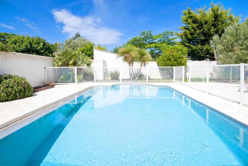 a swimming pool with blue water in a backyard at "MORANDE" grande maison avec Piscine Chauffée in La Noue