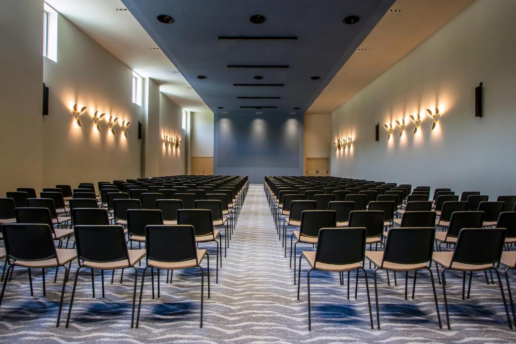 an empty room with rows of chairs and lights at Ammoa Luxury Hotel & Spa Resort in Nikiti