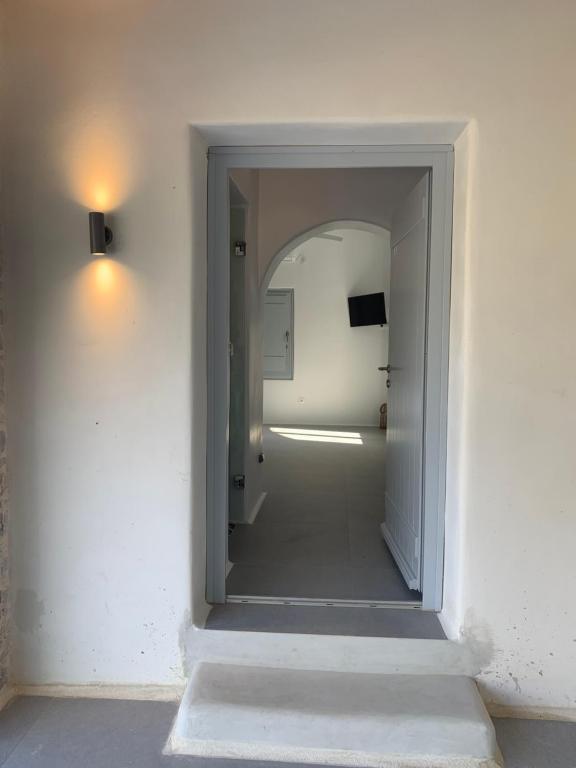 a hallway with a mirror in a white wall at Thomas Villas on the beach Katapola in Katapola