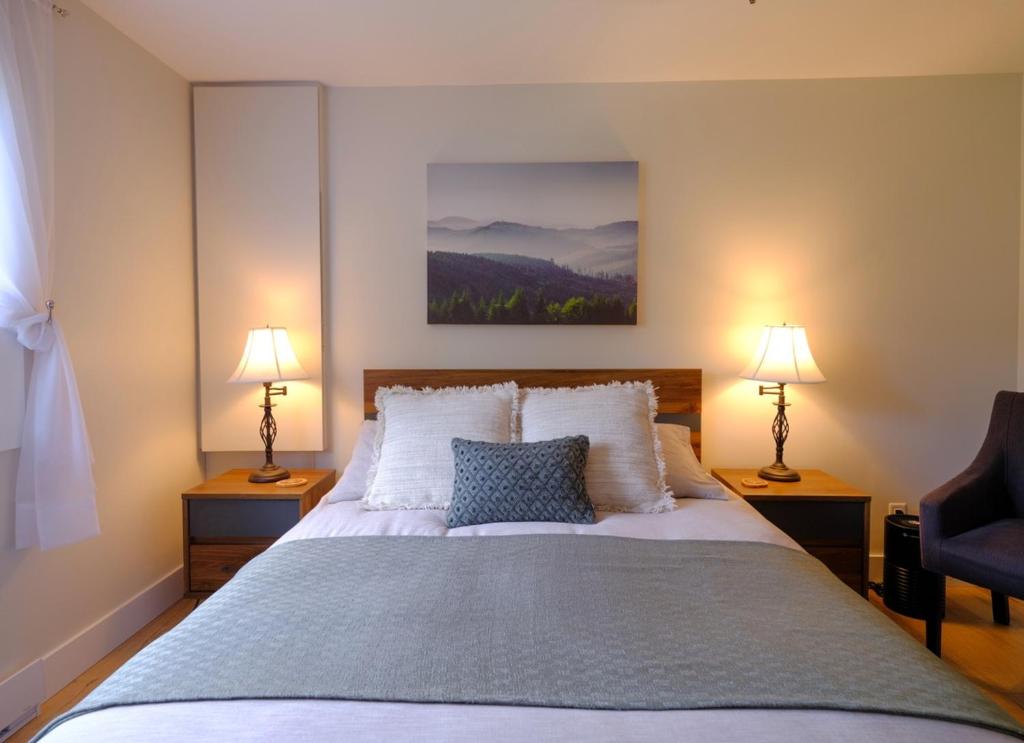a bedroom with a large bed with two lamps at Le Pimbina in Mont-Tremblant