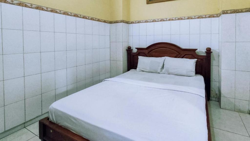 Postel nebo postele na pokoji v ubytování Hotel Shinta 1 near Stasiun Kertosono Mitra RedDoorz