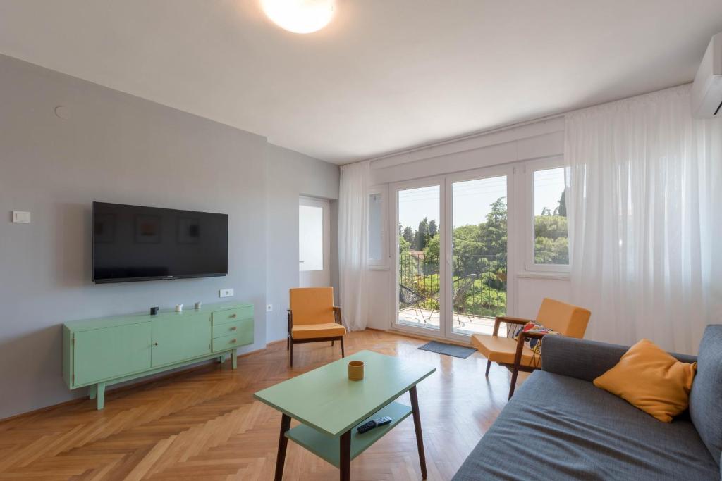 un soggiorno con divano blu e TV di Nona Mileva Apartment a Pola (Pula)