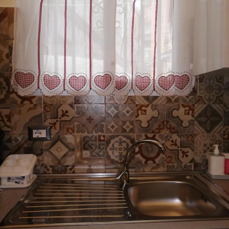 une cuisine avec un évier et une fenêtre dans l'établissement Dimora Genovesi, à Catane