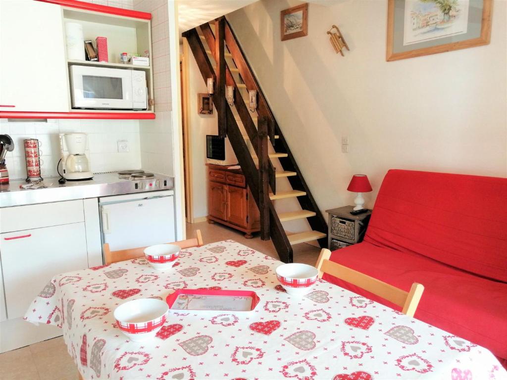 une petite cuisine avec une table et un canapé rouge dans l'établissement Appartement Morillon 1100, 3 pièces, 5 personnes - FR-1-412-19, à Morillon