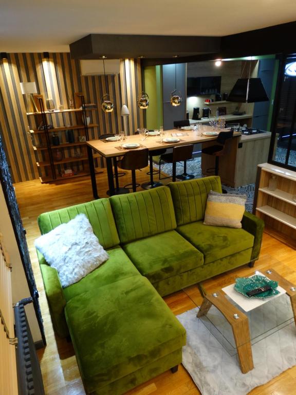- un salon avec un canapé vert et une table dans l'établissement APPARTEMENTY COCO MANGO, à Bourges