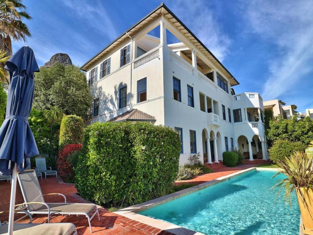 uma casa com piscina em frente a uma casa em The Walden Suites em Cidade do Cabo