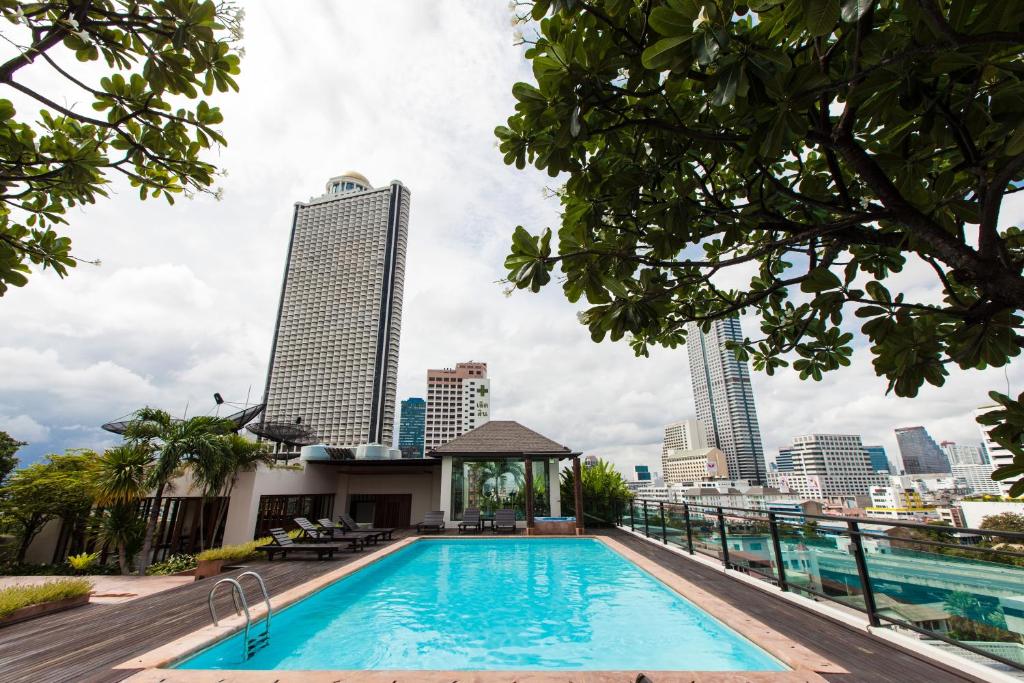 a swimming pool with a city skyline in the background at The Grand Sathorn in Bangkok