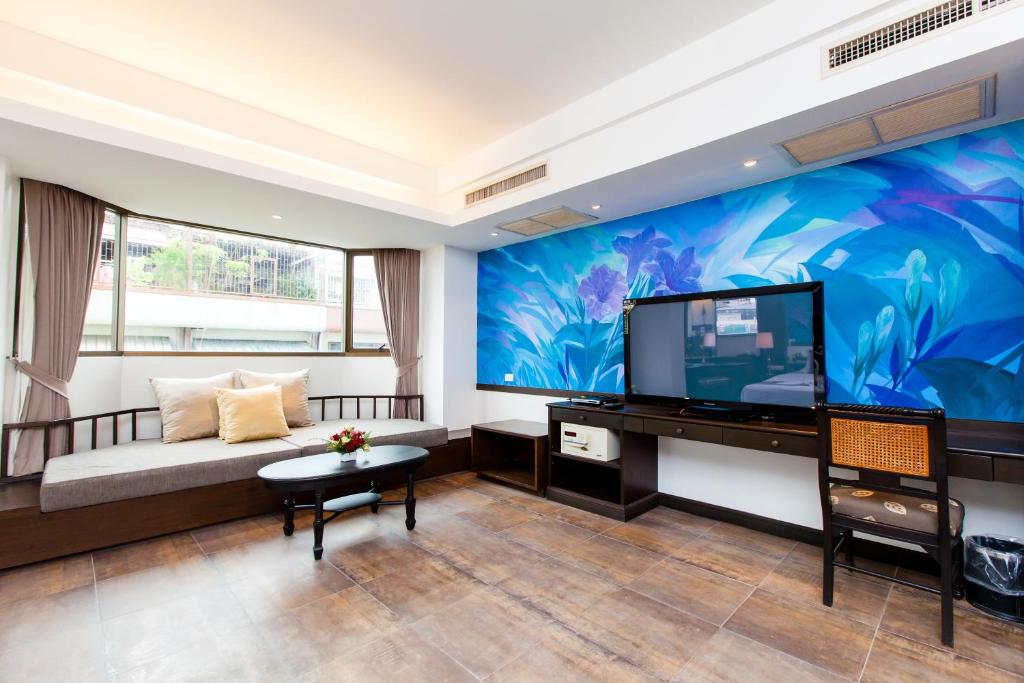 a living room with a large flat screen tv at The Grand Sathorn in Bangkok