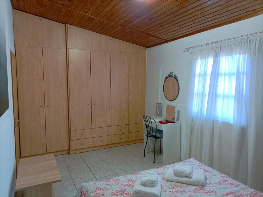 Schlafzimmer mit einem Bett, einem Schreibtisch und einem Fenster in der Unterkunft 4 seasons in Lávrio