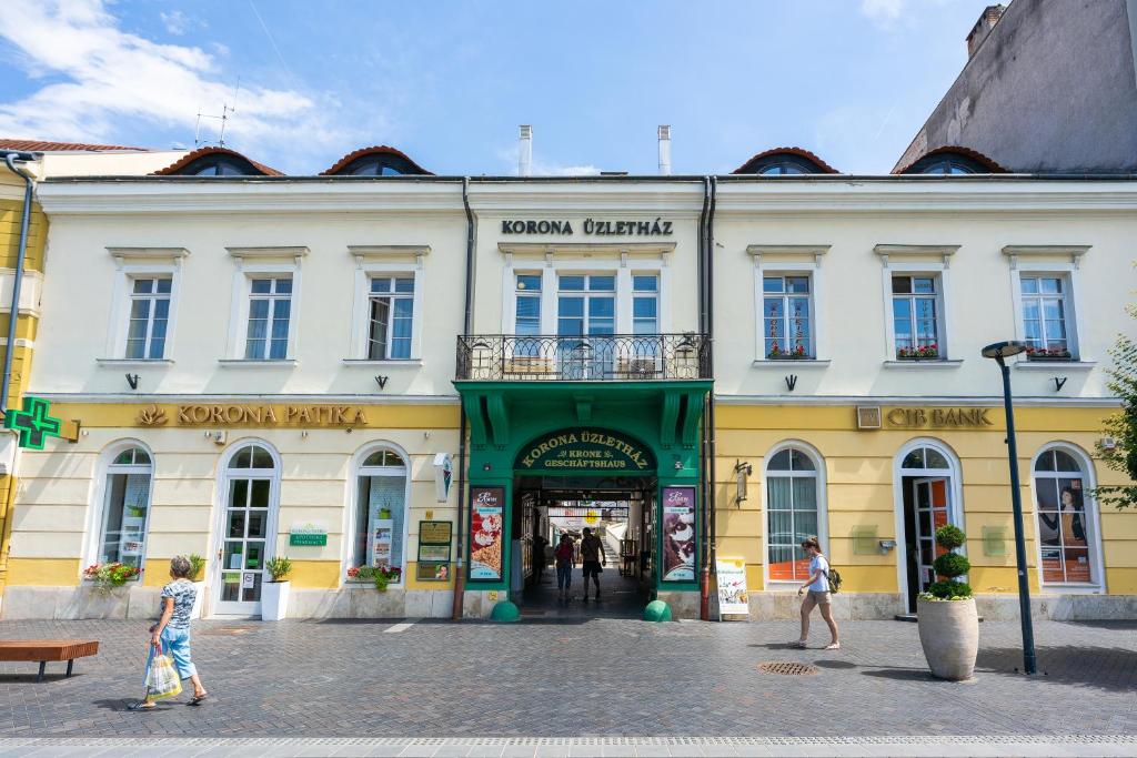 grupa ludzi przechodzących przed budynkiem w obiekcie Weissmann Residence w mieście Sopron