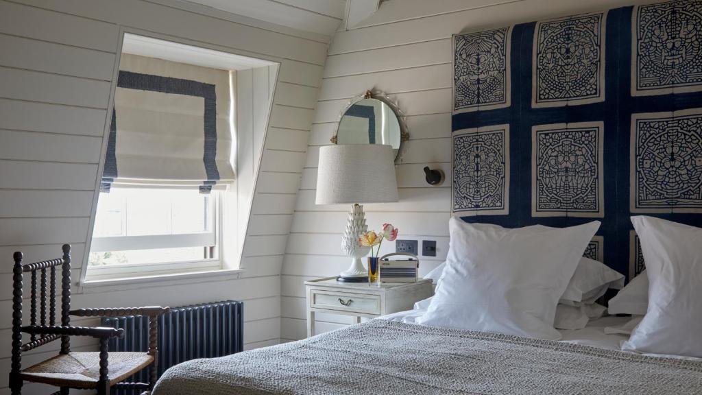 a bedroom with a bed and a chair and a window at The George In Rye in Rye
