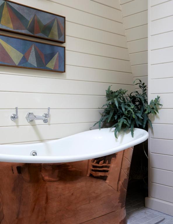 a bathtub with a potted plant in a bathroom at The George In Rye in Rye