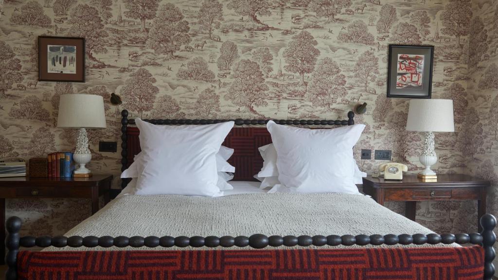 a bedroom with a bed with white pillows and two lamps at The George In Rye in Rye