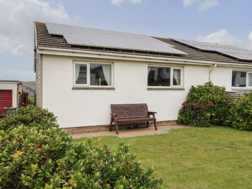 a white house with solar panels on the roof at 7 Atlantic Close in Bude