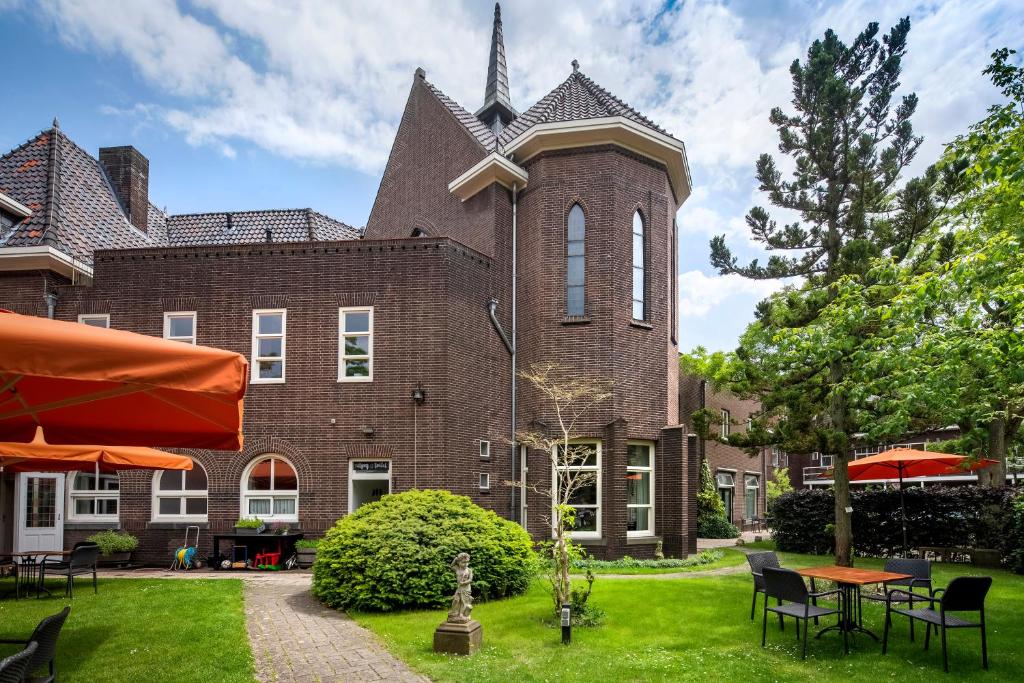 een groot bakstenen gebouw met een klokkentoren bij Kloosterhotel de Soete Moeder in Den Bosch