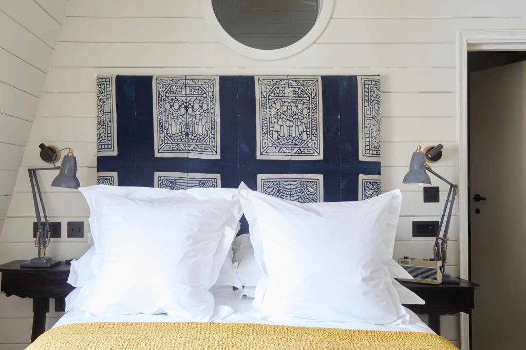 a bed with white pillows and a blue and white wall at The George In Rye in Rye