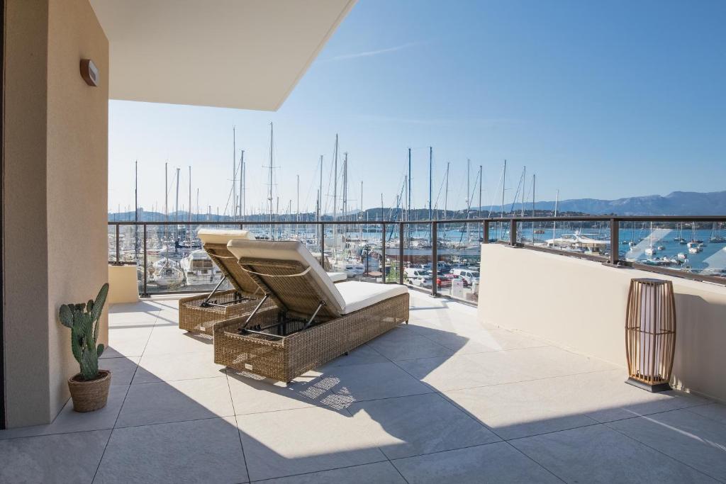 een balkon met stoelen en uitzicht op een haven bij Superbe appartement bord de mer in Saint-Mandrier-sur-Mer