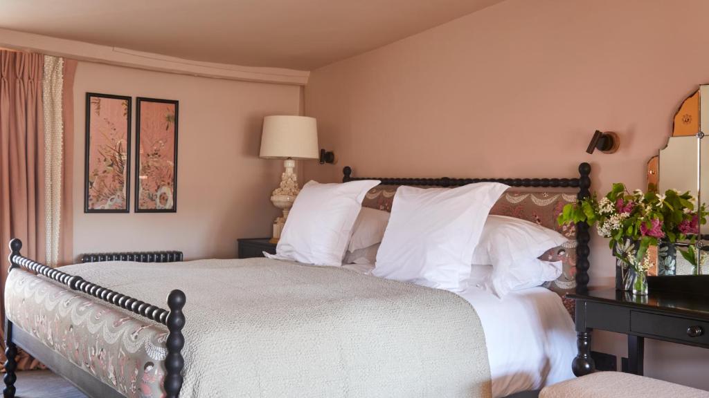 a bedroom with a large bed with white pillows at The George In Rye in Rye
