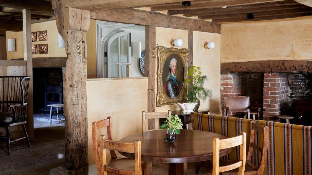 a dining room with a wooden table and a mirror at The George In Rye in Rye