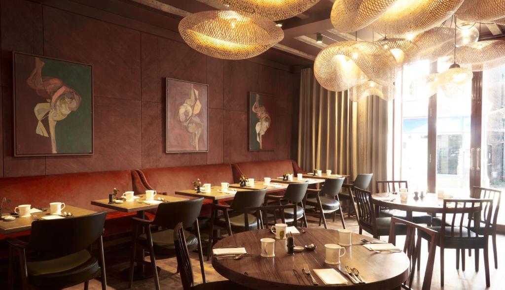 a dining room with tables and chairs and chandeliers at The George In Rye in Rye
