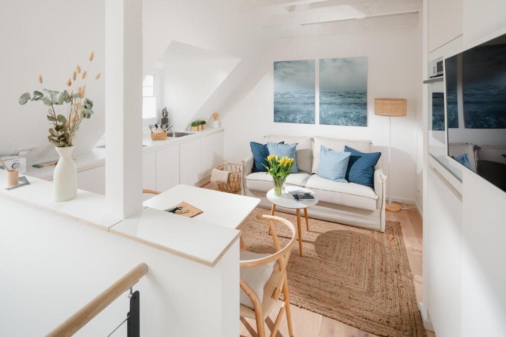- un salon blanc avec un canapé et une table dans l'établissement Haus Salz&Sand Lüttje Tide, à Norderney