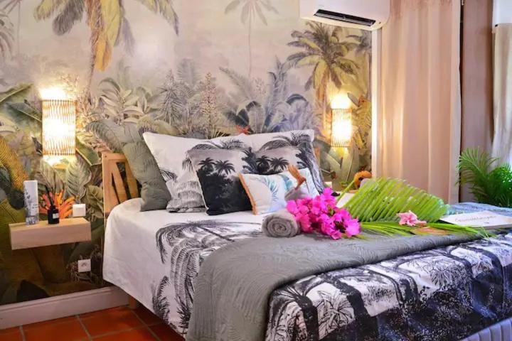 una camera da letto con un letto fiorito di KARIBEKO : Exceptionnel & Rare : Plage , Piscine, WiFi privé a Saint-François