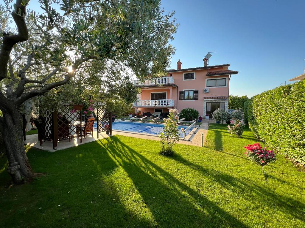 a house with a large yard with a swimming pool at Holiday Home Korenic in Umag