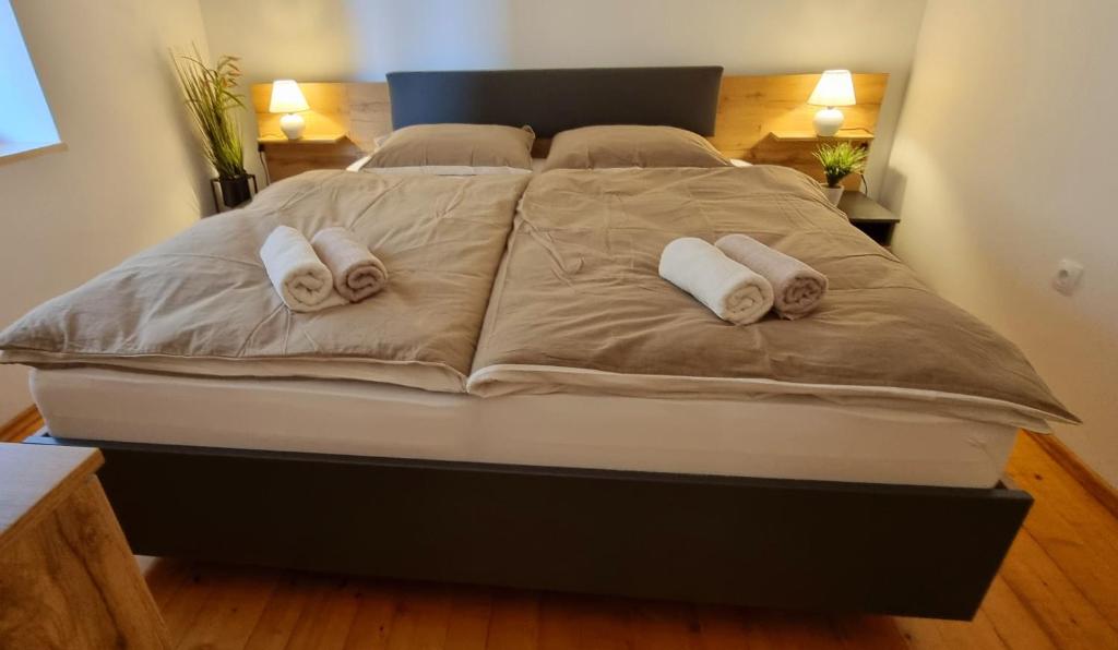 a large bed with two white towels on it at Apartma Metka Bovec in Bovec