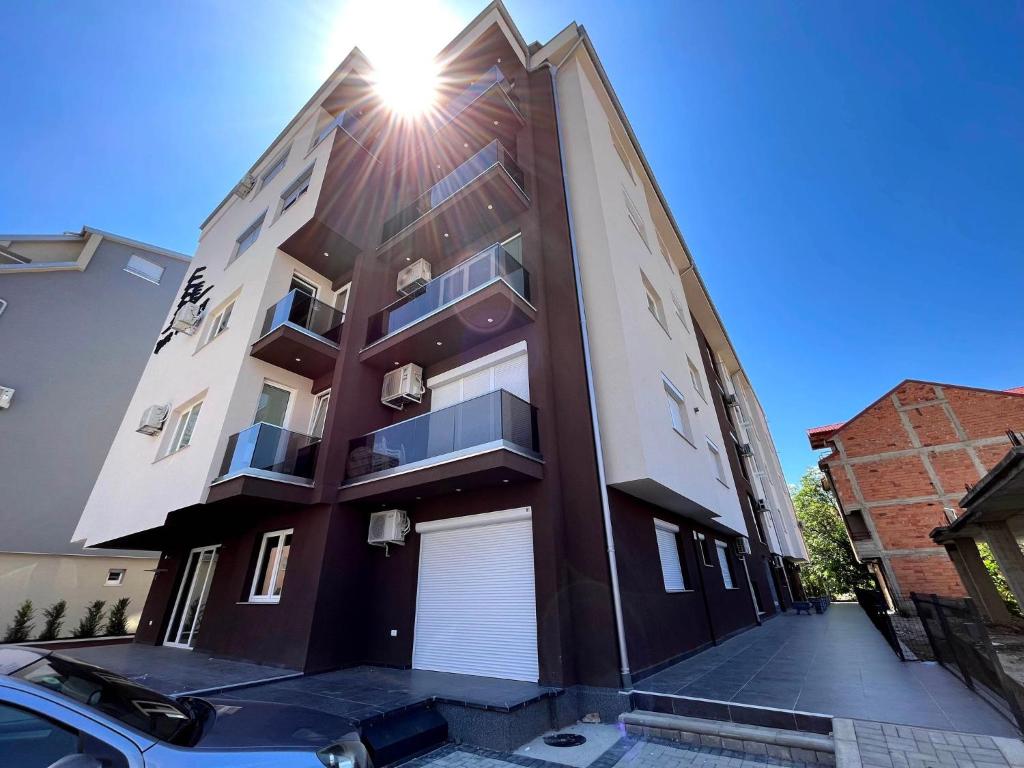 a building with the sun shining on it at Darki Apartments 2 - Very Central Stay With Free Parking in Ohrid