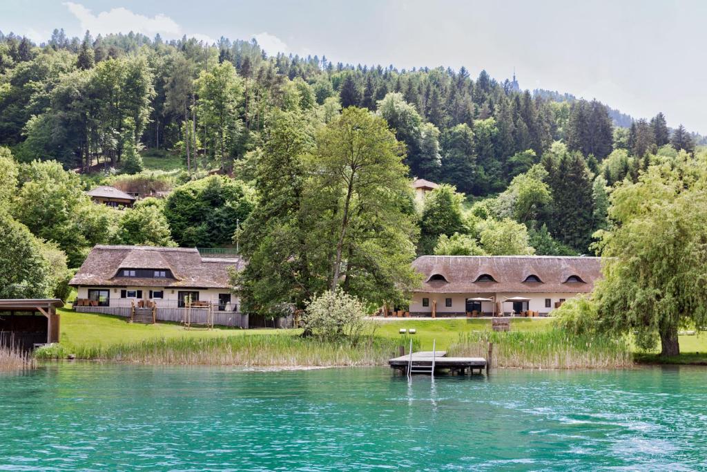 a group of houses on the shore of a lake at Reed by Linde in Maria Wörth