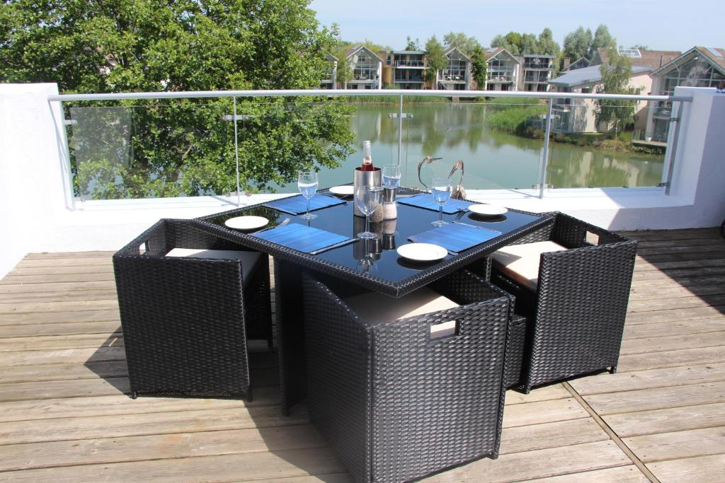 a black table with wicker chairs on a deck at Crow's Nest in Somerford Keynes