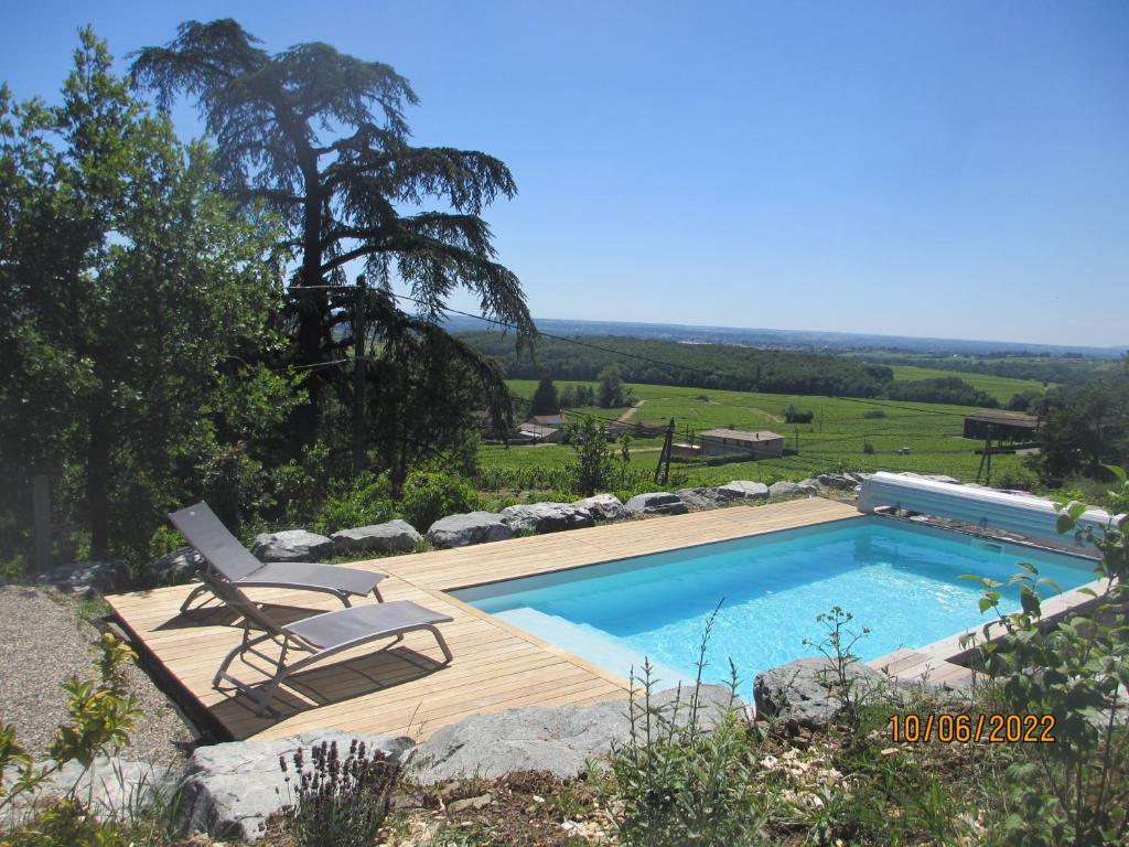 a swimming pool with a chair next to avisor at Gîte le Chêne du Py in Villié-Morgon