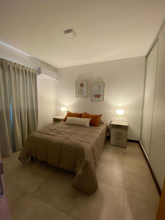 um quarto com uma cama com dois candeeiros em Hermoso departamento céntrico con estacionamiento em Paraná