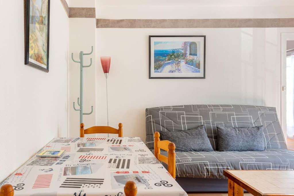 uma sala de estar com um sofá e uma mesa em Charmant T2 proximité Paquebot-les Halles em Saint-Nazaire