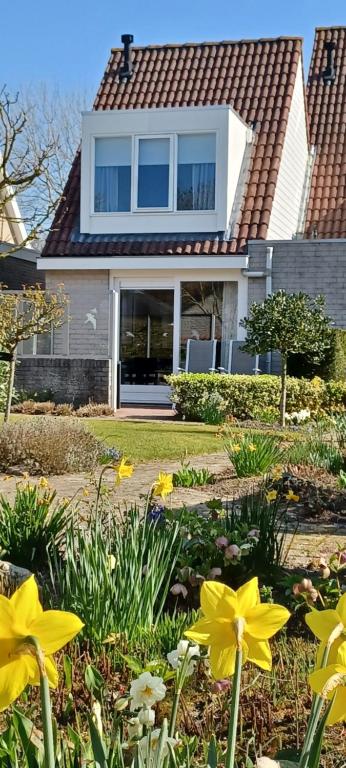 a house with yellow flowers in the front yard at Garden cottage Domburg in Domburg