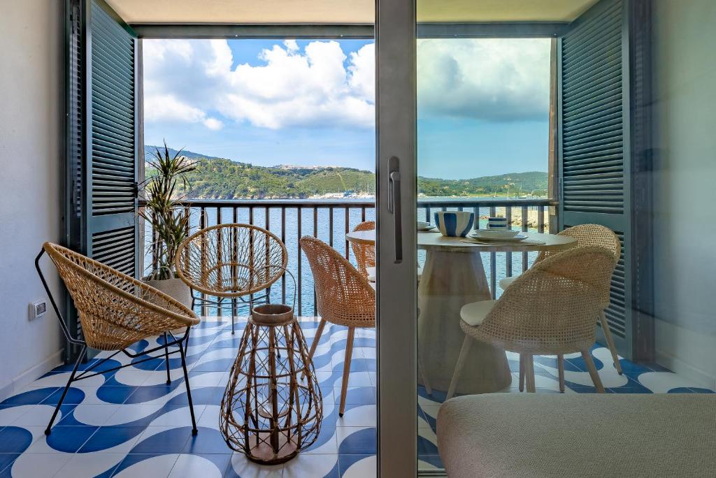 einen Balkon mit Stühlen und einem Tisch mit Aussicht in der Unterkunft Porto Azzurro Suite - Goelba in Porto Azzurro