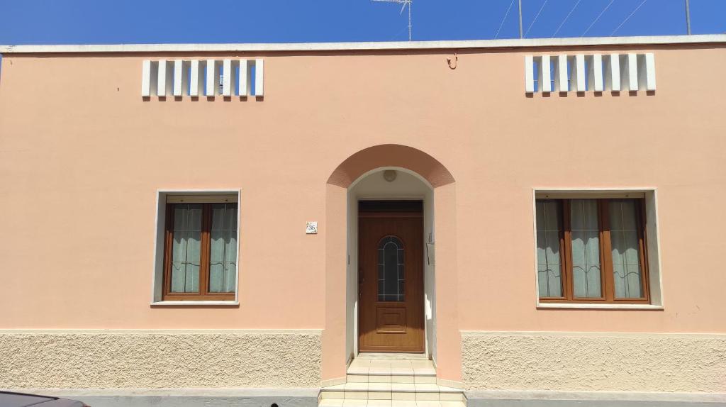 una casa con dos ventanas y una puerta en CASA TRIFO, en Tiggiano