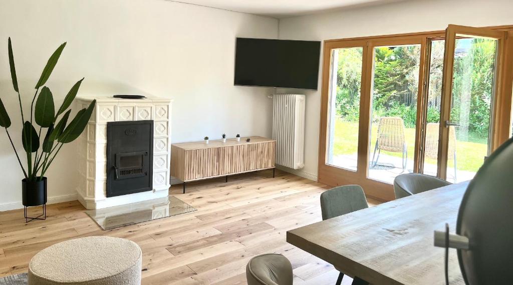 een woonkamer met een tafel en een open haard bij Bungalow in Rottachs Bestlage in Rottach-Egern